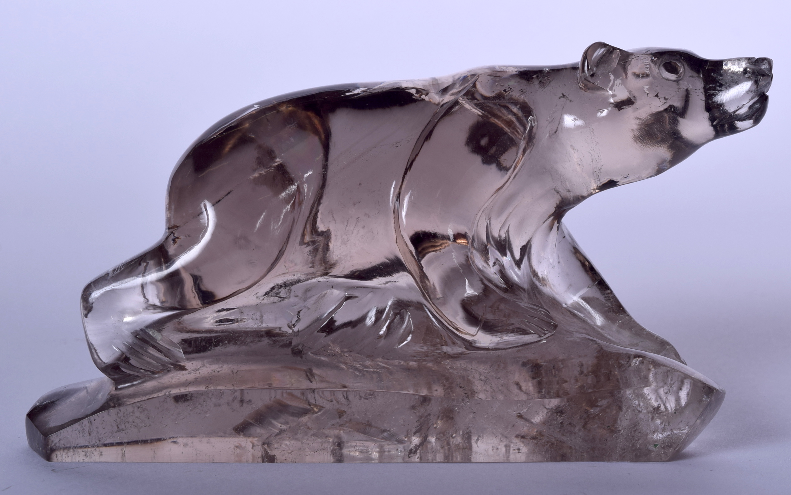 A 20TH CENTURY CARVED ROCK CRYSTAL FIGURE OF A BEAR, formed upon a naturalistic base. 9 cm x 15 cm.