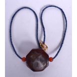 A MIDDLE EASTERN AGATE PENDANT ON LAPIS LAZULI BEAD NECKLACE, carved with a beast. 46 cm long.