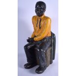 A LARGE 1950S PAINTED PLASTER FIGURE OF A SEATED BLACKAMOOR. 50 cm x 20 cm.