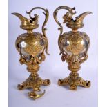 A PAIR OF EARLY VICTORIAN BRONZE AND SILVER PLATED EWERS overlaid with foliate capped crests. 27 cm