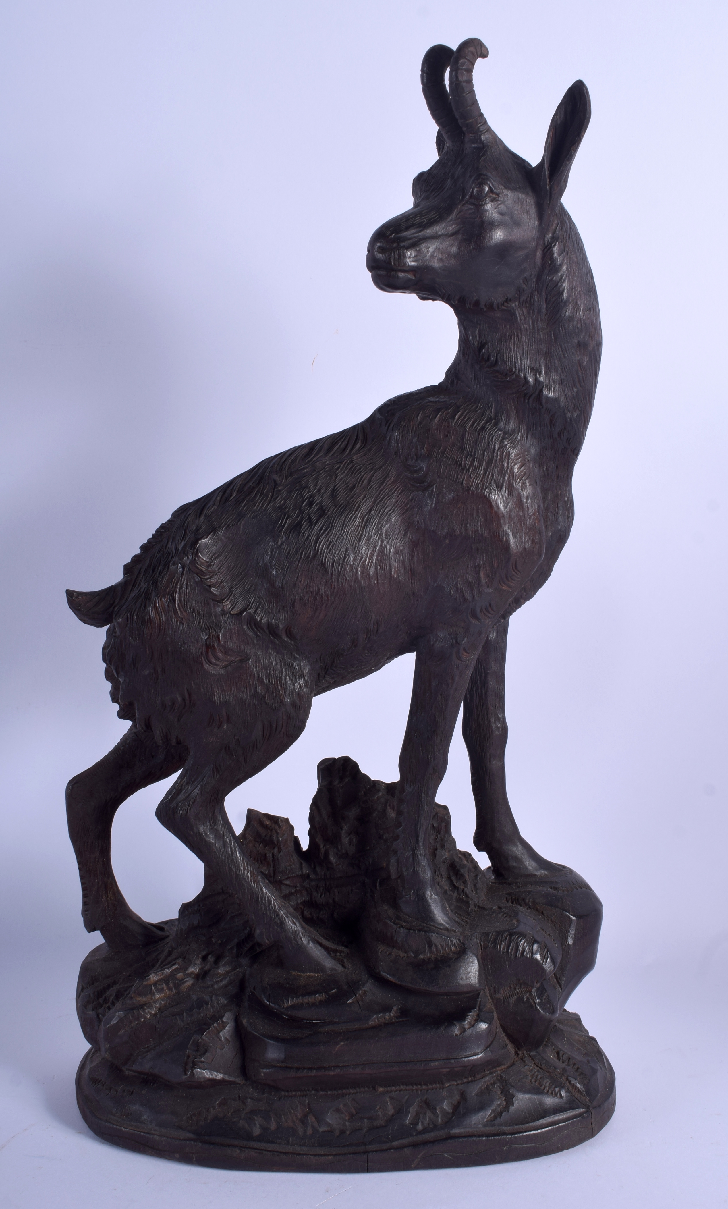 A LARGE ANTIQUE BAVARIAN BLACK FOREST STANDING STAG IBEX modelled upon a naturalistic base. 44 cm x