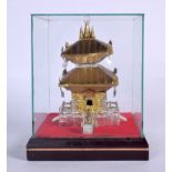 A CHINESE TIN MODEL OF A TEMPLE, contained within a Perspex case. 19 cm x 16 cm.