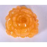 AN AMBER TYPE CARVED CHINESE PENDANT, depicting a flower. 4 cm wide.