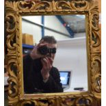 AN ANTIQUE FLORENTINE GILTWOOD MIRROR, formed with scrolling border. 42 cm x 37 cm.