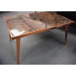 A STYLISH 1950'S ABSTRACT COFFEE TABLE, formed upon splayed copper legs. 44 cm x 84.5 cm.