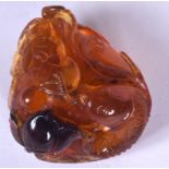 A CHINESE AMBER BOULDER, carved with fish. 5.25 cm x 4.5 cm.