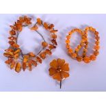 AN AMBER NECKLACE, together with another necklace and a brooch. Longest 70 cm. (3)