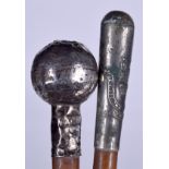 A SILVER TOP SWAGGER STICK, together with another similar. Longest 76 cm. (2)