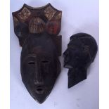 AN IVORY COAST YOHURE WOODEN MASK, together with a wall mask. Largest 36 cm x 19 cm.