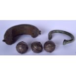 AN AFRICAN BRONZE BANGLE, together with another and three bells. Largest 12.5 cm wide. (5)