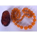 AN AMBER TYPE NECKLACE, together with a boulder. Necklace 66 cm long. (2)