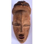 A WEST AFRICAN WOODEN DAN MASK, formed with a ribbed top. 31 cm x 14 cm