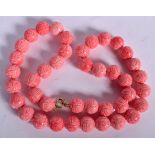 A CHINESE PINK CORAL NECKLACE, formed with carved beads. 48 cm long.