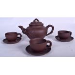 A CHINESE YIXING POTTERY TEA POT, together with three cups and saucers. Tea pot 22 cm wide.