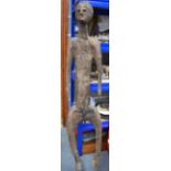 A LARGE AFRICAN CARVED WOODEN FIGURE, formed as a standing nude male. 150 cm long.