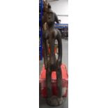 A LARGE WEST AFRICAN CARVED WOODEN STATUE, formed as an elongated female with a bird on her head. 1