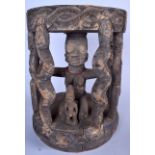 A WEST AFRICAN CARVED POLYCHROMED TRIBAL STOOL, formed as a central female caged within figures and
