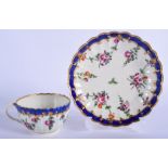 18th c. Worcester teacup and saucer of fluted form painted with flowers under a blue and gilt borde