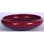 A LARGE FLAMBE GLAZED PORCELAIN BOWL, of plain form. 31 cm wide.