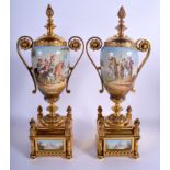 A PAIR OF LATE 19TH CENTURY FRENCH TWIN HANDLED PORCELAIN ENAMELLED URNS AND COVERS with gilt metal