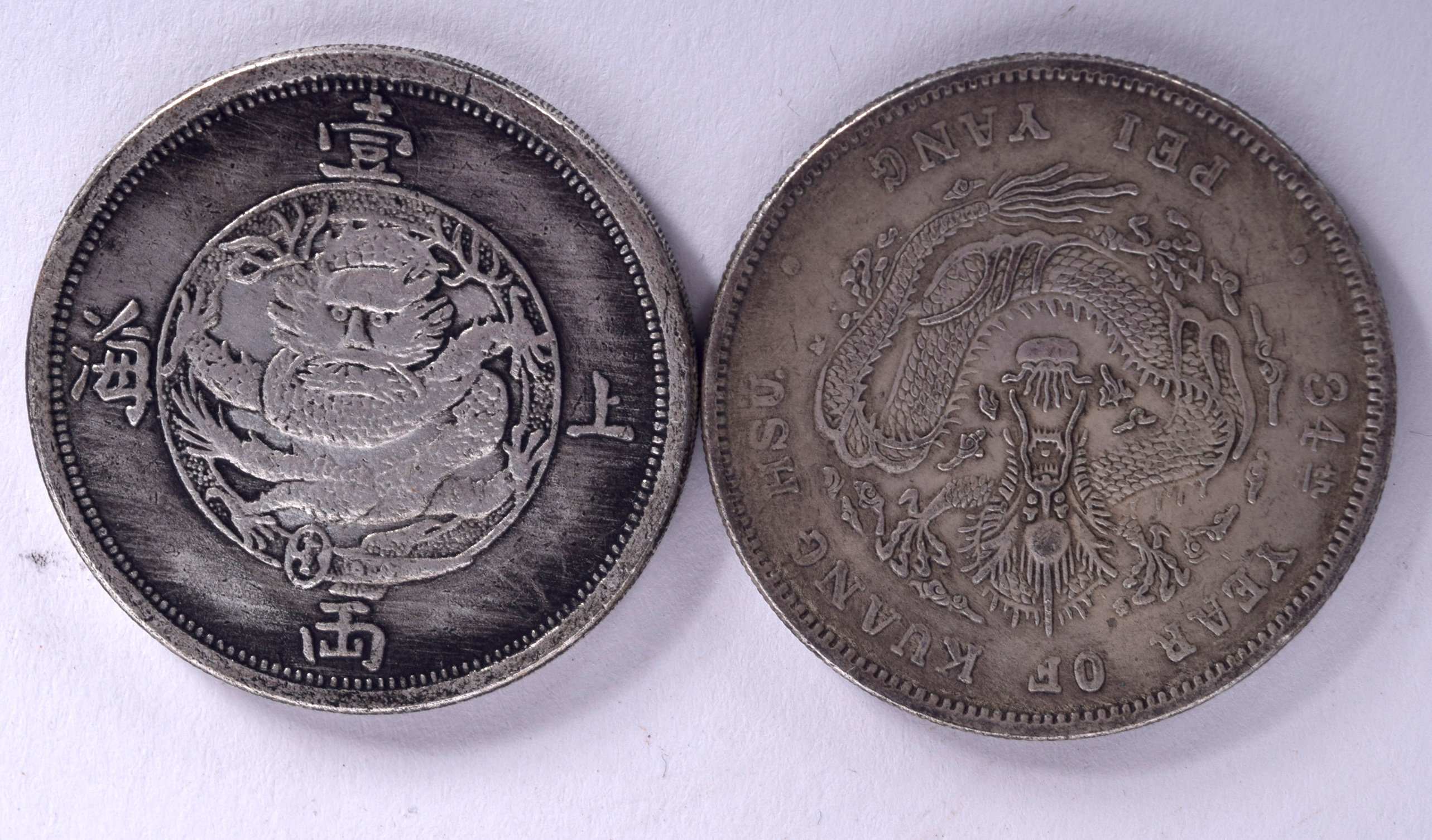 TWO CHINESE WHITE METAL COINS, “One Tael Shanghai”, with another similar. 3.75 cm wide. (2)