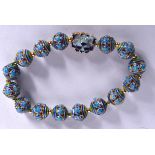 AN ENAMEL BRACELET, formed with floral decorated beads. 7 cm wide.