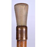 AN EARLY 20TH CENTURY COW HORN HANDLED WALKING CANE, formed with a yellow metal collar. 86 cm long.