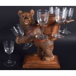 A 19TH CENTURY BAVARIAN BLACK FOREST ROAMING BEAR modelled holding six glasses. 28 cm x 32 cm.