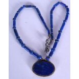 AN EARLY 20TH CENTURY LAPIS LAZULI CARVED NECKLACE, formed with an oval pendant. 52 cm long.
