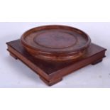 AN EARLY 20TH CENTURY CHINESE CARVED HARDWOOD STAND, formed with a square footed base and circular