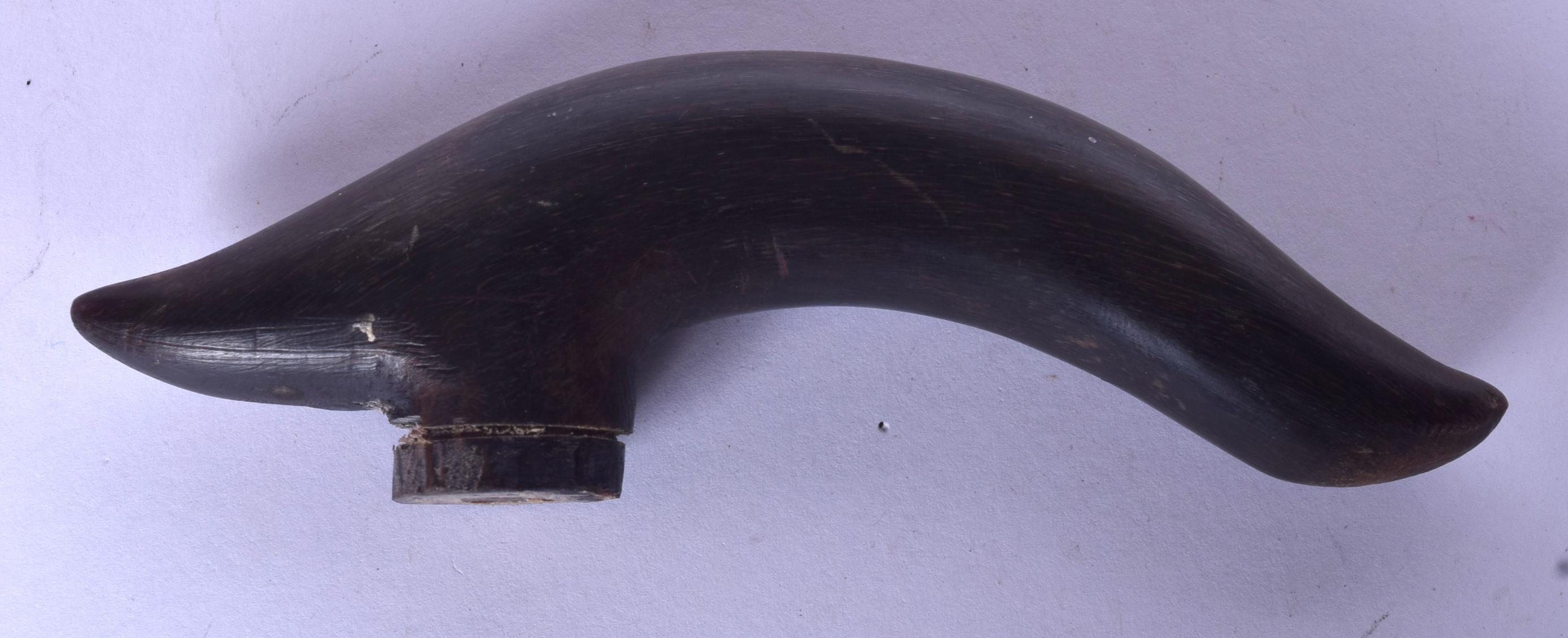 A EARLY 20TH CENTURY RHINOCEROS HORN CANE HANDLE, curved in form. 13.5 cm wide.