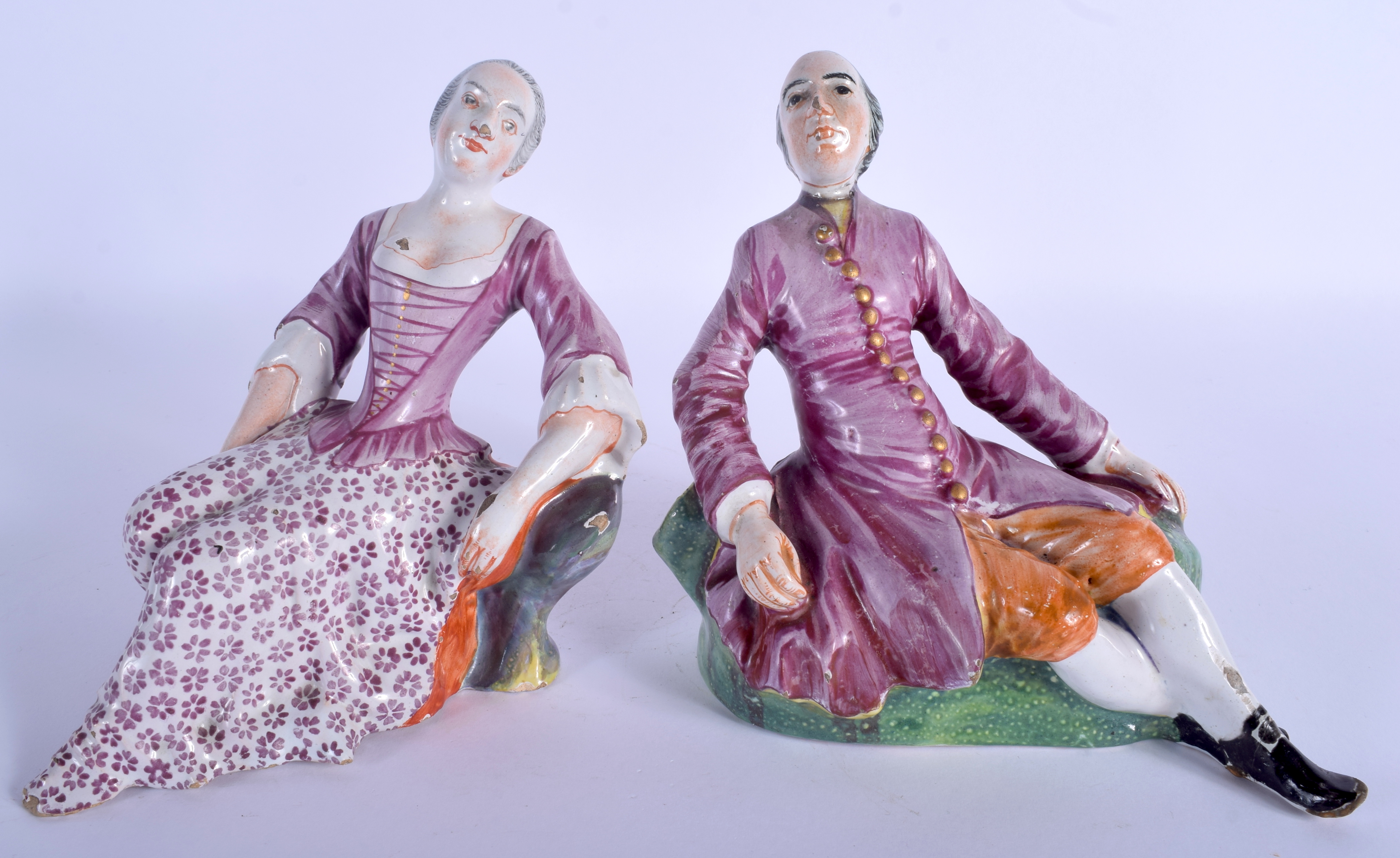 A PAIR OF 18TH CENTURY DUTCH DELFT FIGURES OF A MALE AND FEMALE C1750 modelled resting upon outcrop