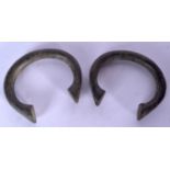A PAIR OF AFRICAN BRONZE BANGLES, of plain form. 8.5 cm wide.