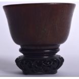 A CHINESE HORN BOWL ON HARDWOOD STAND, formed with a flare rim, probably rhinoceros. Bowl 5.5 cm x
