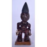 A NIGERIAN YORUBA CARVED WOODEN STATUE, formed as a standing male with an elongated head and shell