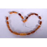 AN AMBER NECKLACE, formed with flattened beads. 34 cm long.