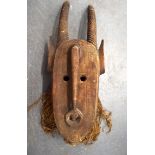 A LIBERIAN WOODEN ZOOMORPHIC TRIBAL MASK, formed with large curving horn. 96 cm x 32 cm.