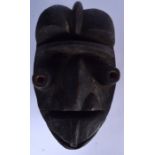 AN IVORY COAST WOODEN KRAN MASK, formed with slit eyes and a large nose. 31 cm x 18.5 cm.