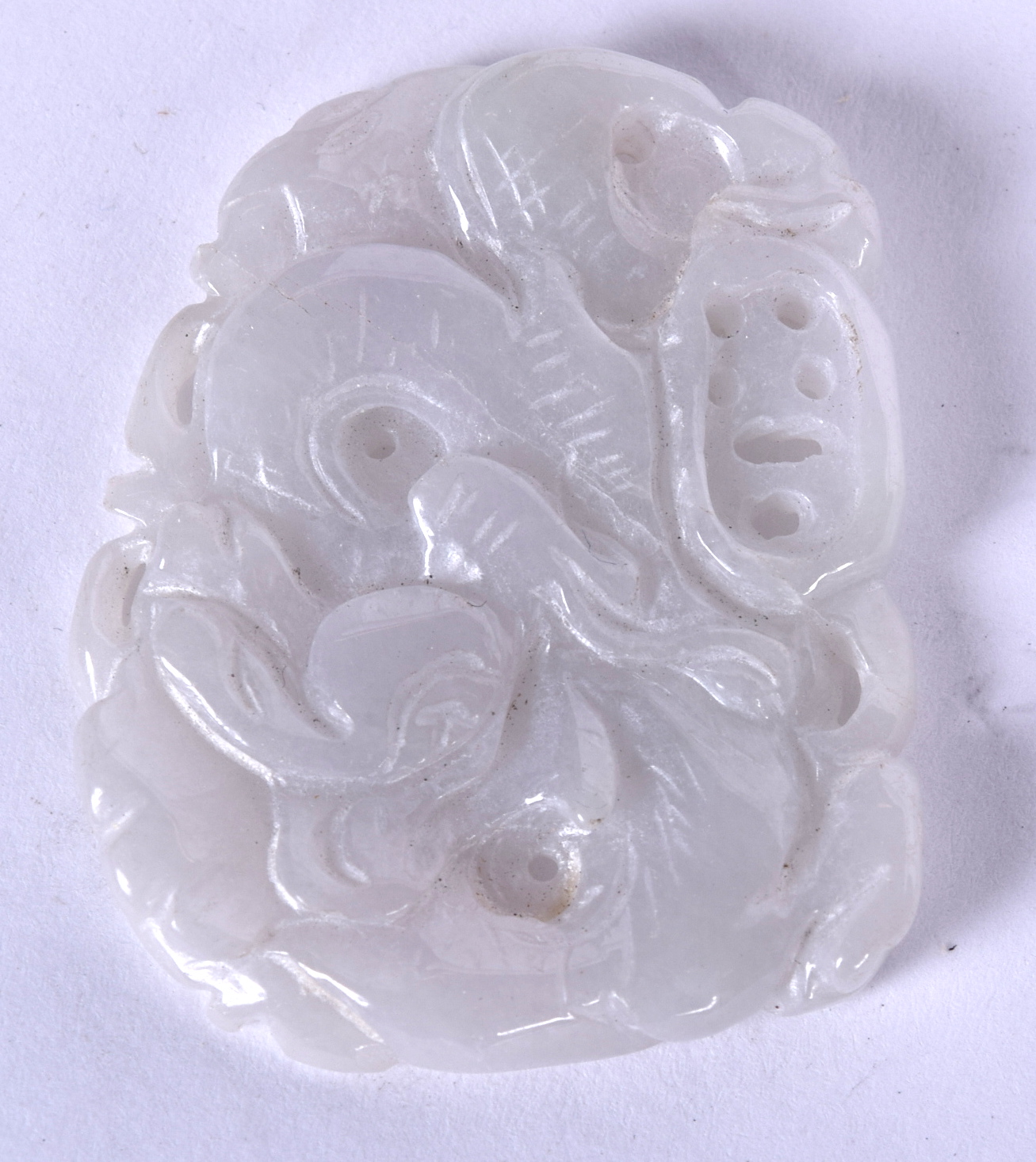 AN EARLY 20TH CENTURY CHINESE CARVED JADE PLAQUE PENDANT, forming mythical creatures amongst foliag