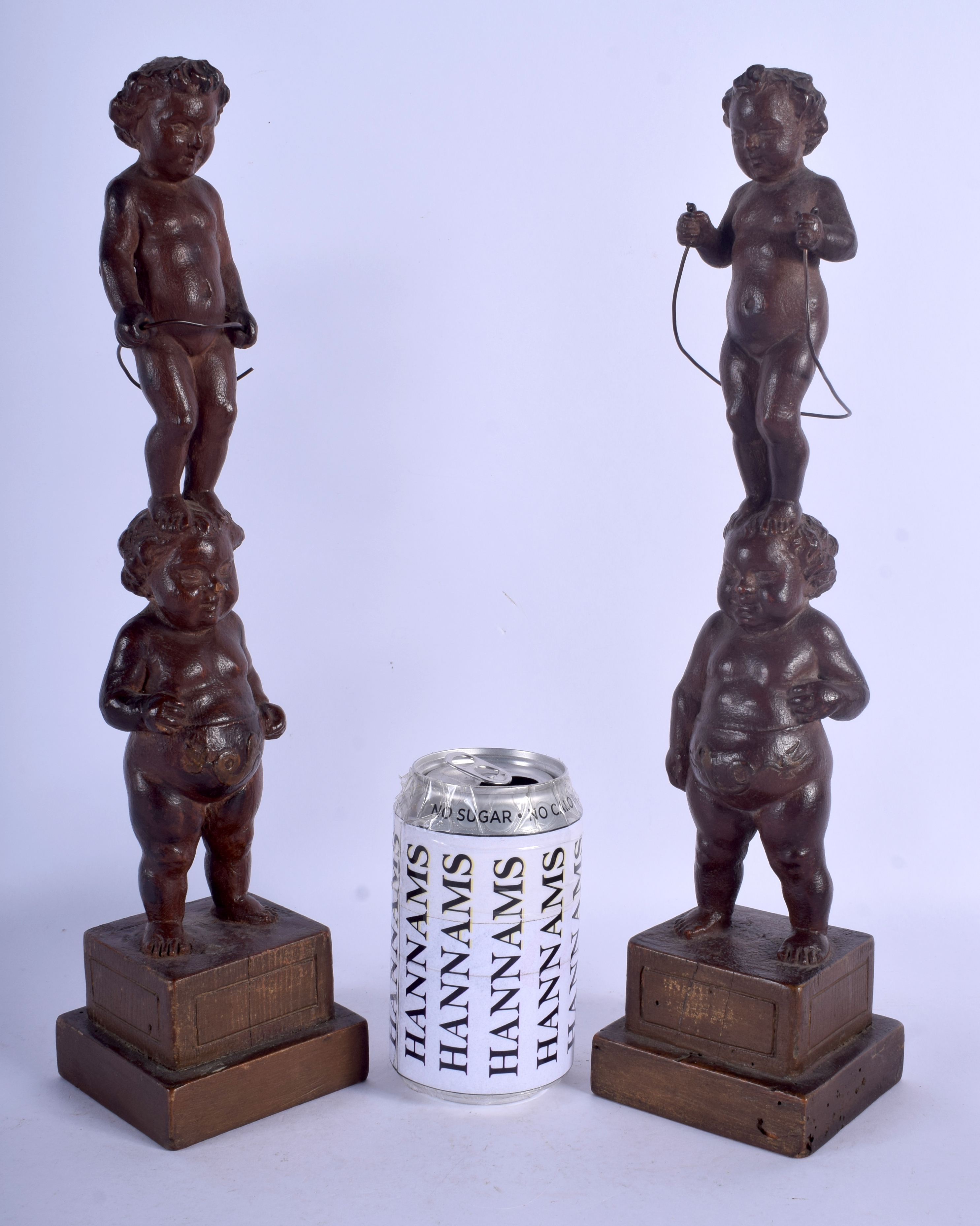 A PAIR OF 19TH CENTURY CONTINENTAL CARVED WOOD FIGURE OF PUTTI modelled upon square form bases. 35.