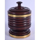 AN ANTIQUE CARVED TREEN CYLINDRICAL RIBBED BOX AND COVER with brass mounts. 17 cm x 9 cm.