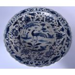 A CHINESE MING STYLE PORCELAIN CHARGER, decorated with a bird flanked by stylised foliage. 45 cm wi