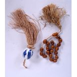 A BLUE AND WHITE PORCELAIN TASSEL, together with a wooden bead bracelet. (2)