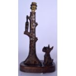 A BLACK FOREST CARVED FIGURAL LAMP, formed as a seated dog beside a cat in a tree. 33 cm high.