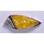 AM AMBER TYPE PENDANT, formed with white metal mounts. 5.25 cm long.