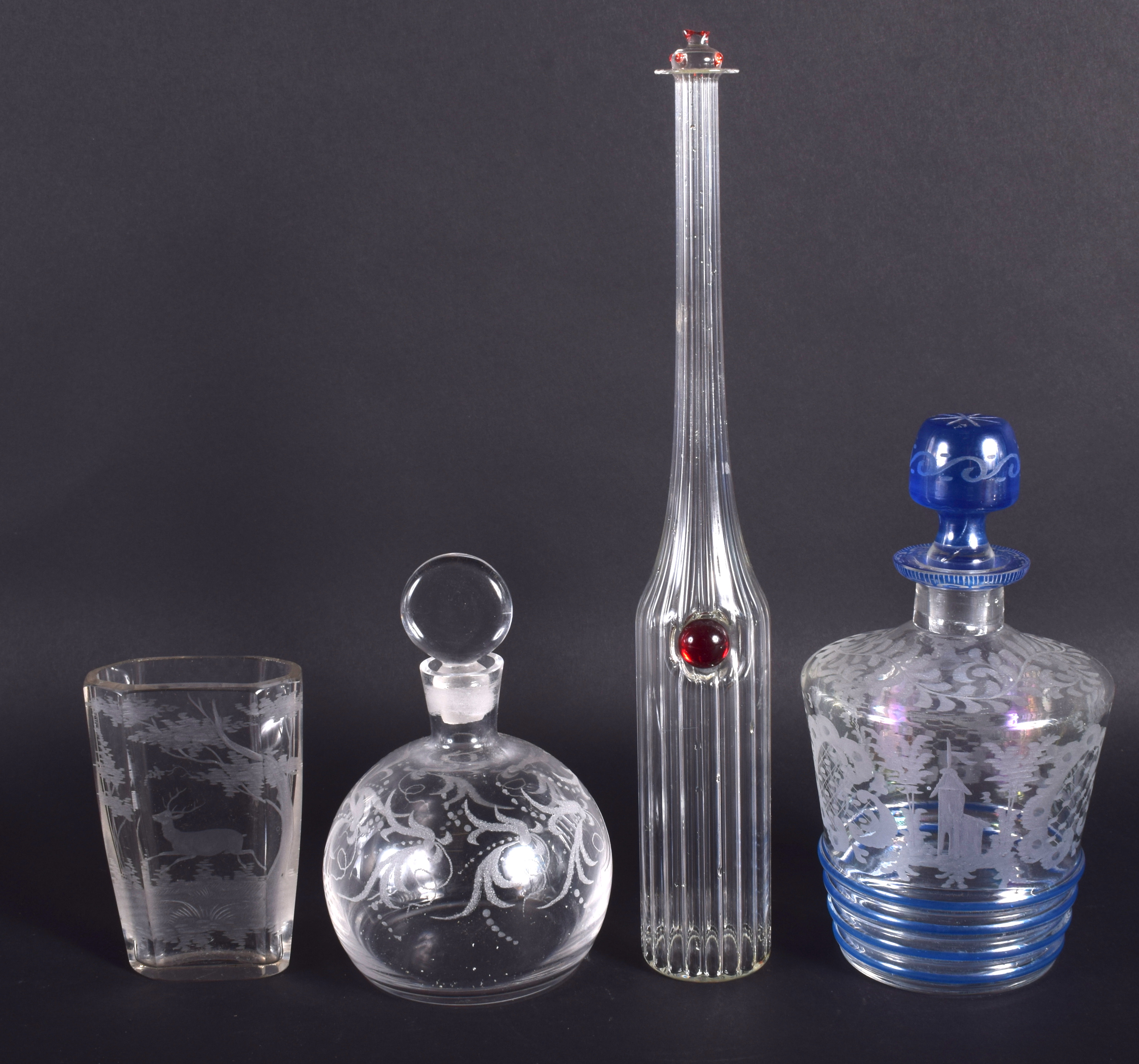 AN ANTIQUE BOHEMIAN CLEAR GLASS VASE together with three bottles. Largest 29 cm high. (4)
