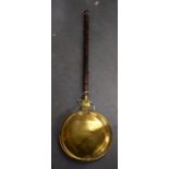 AN EARLY 20TH CENTURY BRASS BED WARMING PAN. 111 cm long.