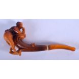 A RARE EARLY 20TH CENTURY CARVED AMBER EROTIC PIPE formed as a female leaning over a book. 8 grams.