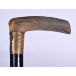 AN EARLY 20TH CENTURY RHINOCEROS HORN HANDLED WALKING STICK, formed with a yellow metal collar. 87