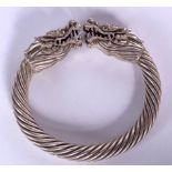 A CHINESE WHITE METAL BANGLE, formed with a rope twist body and opposing dragon heads. 9.5 cm wide.